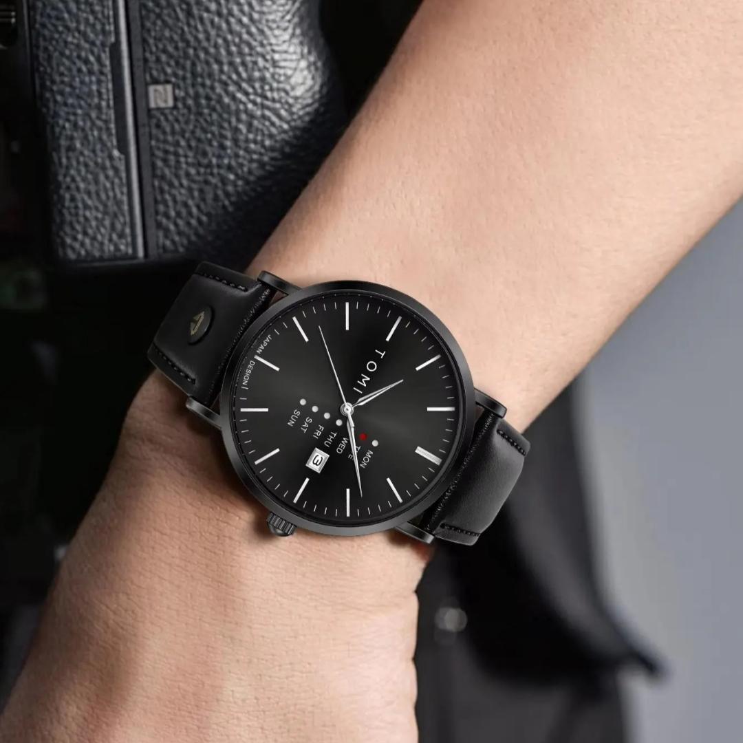 Montre homme TOMI noire, cadran noir et bracelet en cuir noir, portée au poignet