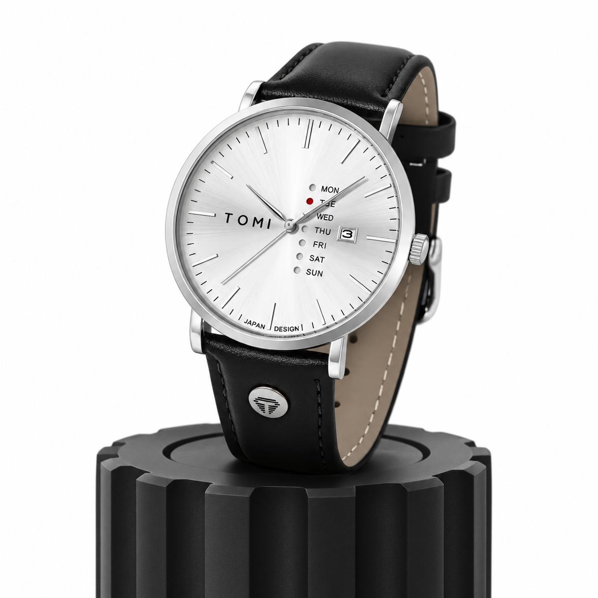 Montre TOMI T-019 Maverick à cadran blanc et bracelet en cuir noir, posée sur un socle noir