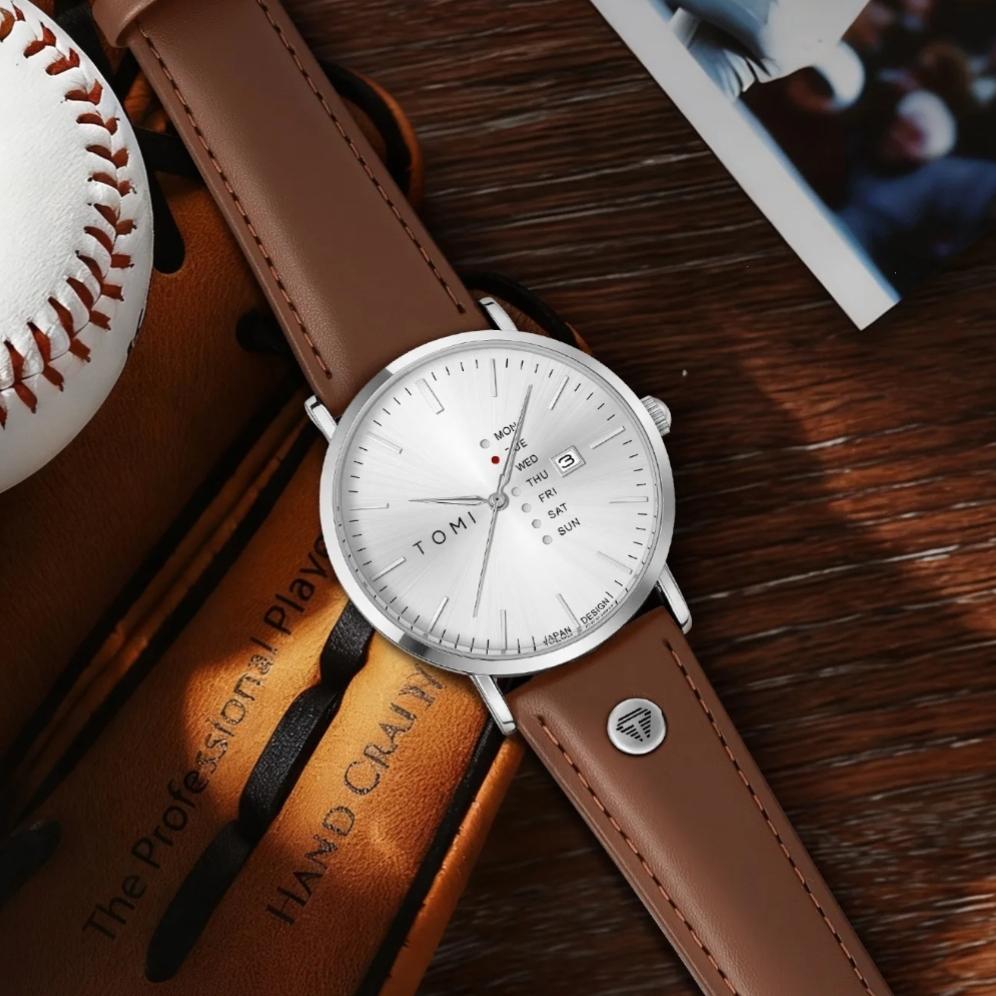 Montre TOMI à cadran blanc et bracelet en cuir marron posée sur un gant de baseball en cuir
